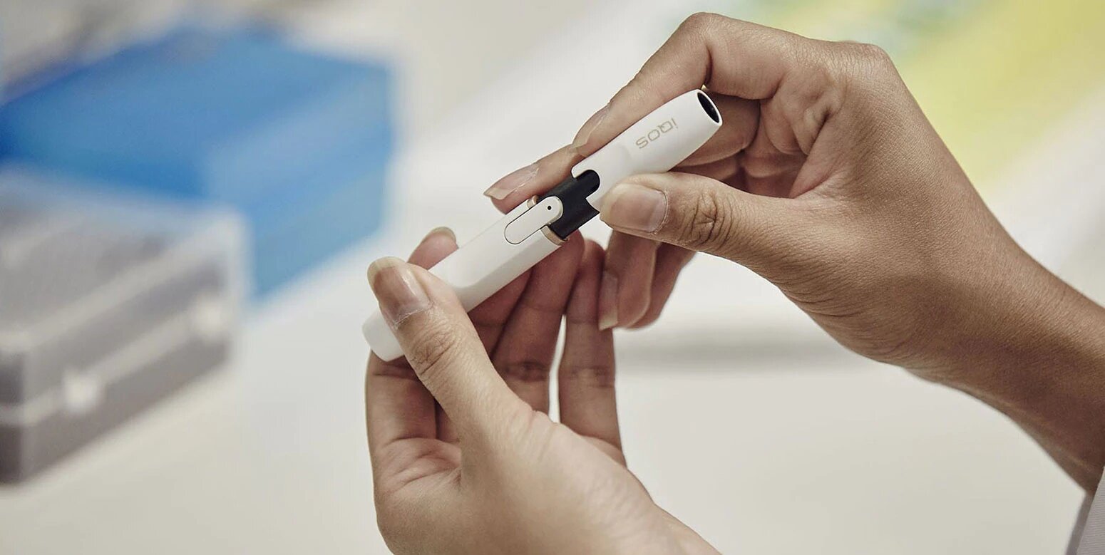 Woman holding IQOS device